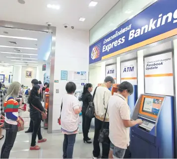  ?? PHRAKRIT JUNTAWONG ?? People use Bangkok Bank ATMs. The central bank is considerin­g a change in fees for cash transactio­ns.