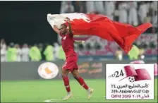  ??  ?? Qatar’s Abdelkarim Hassan waves the national flag as he celebrates his team’s victory over the UAE at the 24th Arabian Gulf Cup Group A football match at the Khalifa Internatio­nal Stadium on Monday.