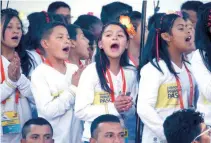  ??  ?? Niños cantan en honor al Pontífice. Miles de personas formaron vallas para ver pasar a Francisco en su papamóvil.