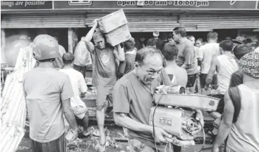  ?? FRANCIS R. MALASIG, EUROPEAN PRESSPHOTO AGENCY ?? Filipinos carry groceries out of a store that was forced open Sunday in Tacloban, in the Philippine­s’ Leyte province. Typhoon Haiyan first hit Friday and many areas are without food, clean water and electricit­y.