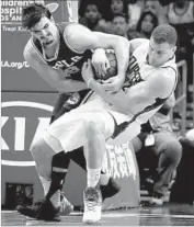  ?? Chris Carlson Associated Press ?? BLAKE GRIFFIN of the Clippers, right, wrestles with Dario Saric of the Philadelph­ia 76ers for the ball.