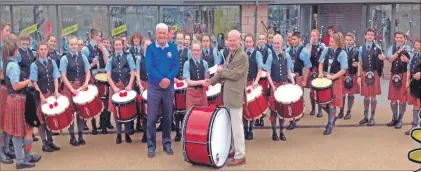  ??  ?? Rotary president Graham Fraser is seen here presenting Oban High School Pipe Band with a cheque for £500 as a donation towards its running costs.