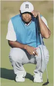  ??  ?? Tiger Woods lines up a putt.