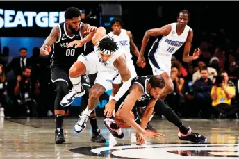  ?? — AFP photo ?? Durant (down, right) of the Brooklyn Nets and Gary Harris (second left) of the Orlando Magic pursue the loose ball during the second half at Barclays Centre in New York City.