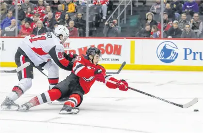  ?? ED MULHOLLAND • USA TODAY SPORTS ?? Ottawa Senators defenceman Ron Hainsey knocks New Jersey Devils' Jack Hughes off the puck during NHL action on Nov. 13.