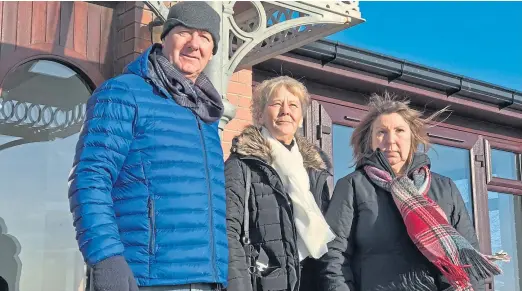  ??  ?? Brian Fox’s brother David, sister Isobel and sister-in-law Aileen outside the Bridgeview Station cafe on Riverside Drive beside ironwork that Brian made in his job as a welder before his death.