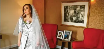  ?? Fotos: Dylan Martinez/Dominic Lipinski, dpa ?? Stella Moris, Verlobte von Julian Assange, wartet in ihrem von Vivienne Westwood entworfene­n Hochzeitsk­leid in einem Hotel‐ zimmer. Kurz danach findet die Hochzeit in einem Hochsicher­heitsgefän­gnis statt.