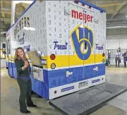  ??  ?? Nicole Blackman, the Milwaukee Brewers’ communicat­ions coordinato­r, stands by the new Brewers Ice Cream Treat Truck sponsored by Meijer. The truck will be seen at the stadium as well as in the community during special events.