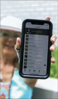  ?? EMILIANO RODRIGUEZ MEGA — THE ASSOCIATED PRESS ?? Susan Hewitt poses for a picture showing her profile on iNaturalis­t, the app where she records all the plants and animals she finds in New York City. With 7,379 observatio­ns and 736 species identified, Hewitt is the most active member of the EcoFlora...