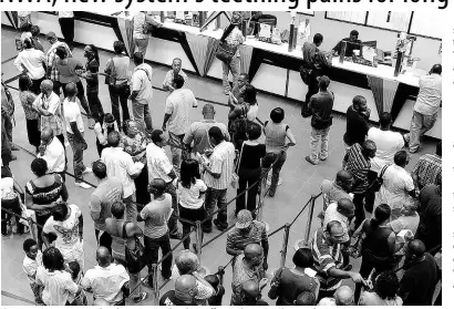  ??  ?? Customers queue to conduct business at a local tax office in this 2012 Gleaner photo.