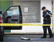  ?? NICK WAGNER / AMERICAN-STATESMAN ?? An Austin police officer works the scene of a shooting Wednesday in the 6700 block of Guadalupe Street that left a store owner dead and another person injured. A suspect was arrested.