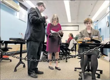  ?? Marina Villeneuve ?? MAINE ELECTION officials examine ballots Friday. The 2nd Congressio­nal District election will be the first in U.S. history decided by a system that factors in voters’ alternativ­e choices. A result is expected this week.