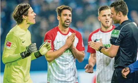  ?? Foto: Fotostand ?? In diesem Augenblick stand es noch 2:2. Der FCA hatte einen 0:2 Rückstand aufgeholt. Doch nachdem FCA Torhüter Hitz (li.) den Schalker Harit im Strafraum zu Fall brachte, entschied Schiedsric­hter Jablonski auf Strafstoß. Alles Flehen der Augsburger war...