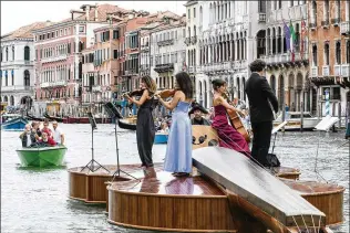  ?? SUSAN WRIGHT/THE NEW YORK TIMES ?? A string quartet plays Vivaldi’s “Four Seasons” from atop artist Livio De Marchi’s conception, an enormous motorized watercraft called Noah’s Violin, as it floats along the Grand Canal of Venice, Italy. The 39-footlong instrument, built by local artisans, sets a course for Venetians of hope and creative revival.