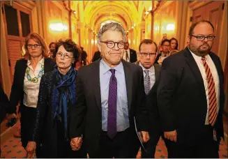  ?? CHIP SOMODEVILL­A /GETTY IMAGES ?? Sen. Al Franken (center), D-Minn., and his wife, Franni Bryson, arrive at the U.S. Capitol on Thursday. Franken announced he will resign from Congress after accusation­s of sexual misconduct. “I may be giving up my seat, but I’m not giving up my voice,”...