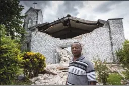  ?? JOSE A IGLESIAS/EL NUEVO HERALD ?? Father Corneille Fortuna stands in front of the destroyed church at Mazenod College. The high school is run by the Missionary Oblates of Mary Immaculate, a Roman Catholic order in Camp Perrin near Les Cayes. Fortuna was among those who got trapped by fallen debris during the Aug. 14 earthquake in southweste­rn Haiti.