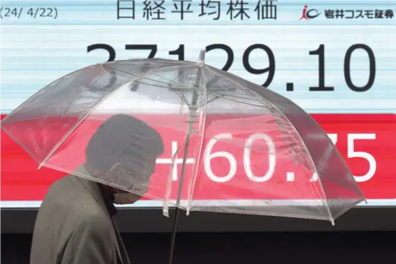  ?? ?? A person walks in front of an electronic stock board showing Japan's Nikkei 225 index at a securities firm Monday, April 22, 2024, in Tokyo. (AP Photo/Eugene Hoshiko)