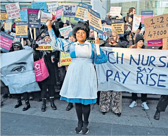  ?? ?? Specialist nurse Ada Ferenkehko­roma takes centre stage on the picket line yesterday at University College Hospital at Euston, central London