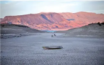  ?? AP PHOTO/JOHN LOCHER ?? A formerly sunken boat sits on cracked earth hundreds of feet from what is now the shoreline on Lake Mead at the Lake Mead National Recreation Area on Monday near Boulder City, Nev.