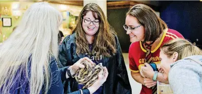  ?? [PHOTO PROVIDED] ?? Science Museum Oklahoma guests inspect a snake at the April SMO 21, an adultsonly, after-hours event for ages 21 and older.