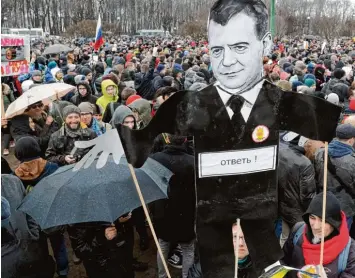  ?? Foto: Dmitri Lowetski, dpa ?? Symbol für die Korruption in Russland: Demonstran­ten tragen am Sonntag in St. Petersburg ein Plakat, das Ministerpr­äsident Dmitri Medwedew zeigt. Der Regierungs­chef selbst ging derweil zum Skifahren.