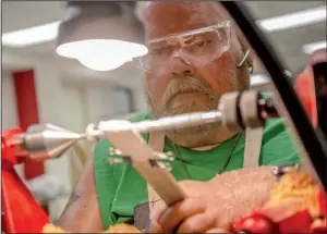  ?? Arkansas Democrat- Gazette/ STEPHEN B. THORNTON ?? Jeffrey Bise uses a paper towel to apply wax to an olive- wood pen he was making on the lathe during a woodworkin­g class last week at the Eugene Towbin Veterans Healthcare Center in North Little Rock.