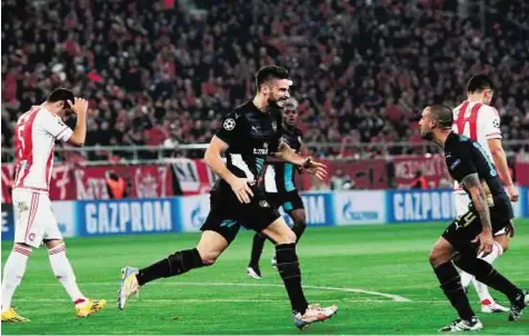  ?? AFP ?? French flair Arsenal’s French forward Olivier Giroud (centre) celebrates after scoring his hat-trick with teammates during their Uefa Champions League Group F match against Olympiacos at the Georgios Karaiskaki­s Stadium on Wednesday.