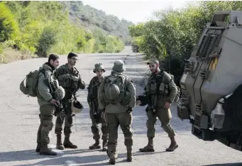  ?? JACK GUEZ/ AFP/GETTY IMAGES ?? Israeli soldiers control the access Monday of one of the roads near Rosh Hanikra on the Israeli-Lebanese border, one day after a Lebanese sniper killed an Israeli soldier.