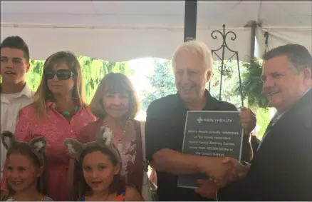  ?? KEVIN MARTIN — THE MORNING JOURNAL ?? Jon Veard, second from right, is presented with a plaque from Ed Oley, right, on July 31 in recognitio­n of his generous contributi­on to Mercy Health-Lorain Hospital which culminated in the Veard Family Birthing Center.