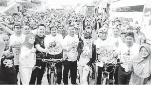  ?? — Gambar Bernama ?? SIHAT: Sharifah (empat kanan) bergambar bersama para peserta basikalton pada Program Fiesta Sehat @ RTM #AKOK25 di Dewan Terbuka Kompleks Uthmaniyah, Kampung Pauh Lima, Pasir Puteh, semalam.