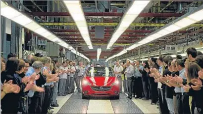  ?? TONI GALÁN / EFE / ARCHIVO ?? Empleados de la planta de Opel en Zaragoza junto a la unidad 12 millones de su línea de producción