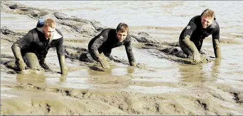  ?? BILD: ANDRE VAN ELTEN ?? Suche im Schlick: Mit vollem Körpereins­atz wühlen sich Polizeibea­mte in Brake durch den Schlick der Weser.