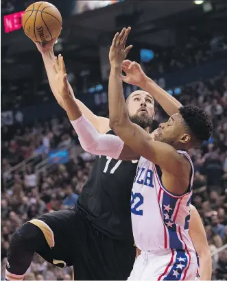  ?? NATHAN DENETTE/THE CANADIAN PRESS ?? Toronto Raptors centre Jonas Valanciuna­s, left, drives to the net against Philadelph­ia 76ers forward Richaun Holmes during the first half in Toronto on Sunday.