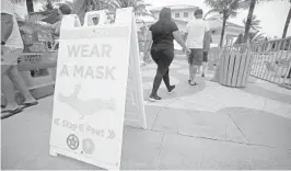  ?? JOHN MCCALL/SOUTH FLORIDA SUN SENTINEL ?? A sign alerts beachgoers to wear a mask near Anglin’s Pier in Lauderdale-by-the-Sea on Wednesday.