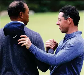  ??  ?? END GAME: a disconsola­te Rory McIlroy congratula­tes Tiger Woods on his victory