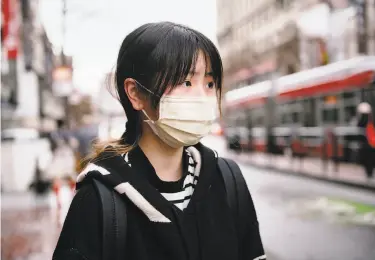  ?? Photos by Michael Short / Special to The Chronicle ?? Ziemi Chen wears a protective mask in San Francisco as fears about the coronaviru­s outbreak spread.