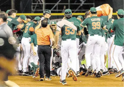  ?? D.A. VARELA dvarela@miamiheral­d.com ?? UM players swarm Carlos Perez after he hit a bases-loaded single with one out in the bottom of the ninth inning Friday in the Hurricanes’ home opening victory over New Jersey Institute of Technology at Alex Rodriguez Park in Coral Gables.