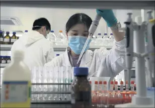  ?? NG HAN GUAN — THE ASSOCIATED PRESS ?? In this Sept. 24, 2020, photo an employee of SinoVac works in a lab at a factory producing its SARSCoV-2 vaccine for COVID-19 in Beijing.