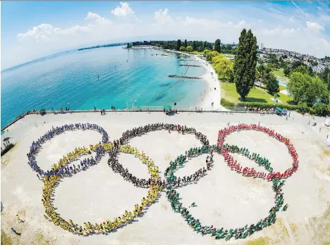  ?? VALENTIN FLAURAUD/KEYSTONE VIA THE ASSOCIATED PRESS ?? About 1,200 children display the Olympic rings last month in Lausanne, Switzerlan­d. The city is the headquarte­rs of the Internatio­nal Olympic Committee, where representa­tives from Paris and Los Angeles are making their cases to host the 2024 Games. With interest in hosting the Olympics waning, cities should demand more financial help from the IOC to cover the huge costs.