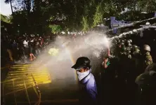  ?? Eranga Jayawarden­a / Associated Press ?? Police fire tear gas and water cannons at protesters during an antigovern­ment rally Thursday in Colombo, Sri Lanka.