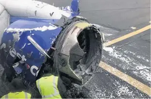  ?? AMANDA BOURMAN VIA AP ?? A Southwest Airlines plane is inspected on the Philadelph­ia Internatio­nal Airport runway after a jet blew an engine and got hit by shrapnel that smashed a window. A woman is dead, and seven others are hurt.