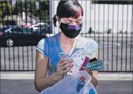  ?? Kent Nishimura Los Angeles Times ?? AT THE COSTUME Designers Guild headquarte­rs in Burbank last Friday, Eileen DenAdel gathers the masks she made during a parking lot workshop.