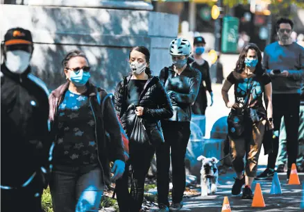  ?? DEMETRIUS FREEMAN/THE NEW YORK TIMES ?? A long line forms for face mask distributi­on May 2 at Prospect Park in the New York City borough of Brooklyn.