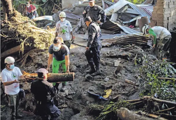  ?? AFP ?? Socorrista­s de la Cruz Roja, policías y soldados trabajaban para remover escombros mientras buscaban posibles víctimas de la avalancha en Nejapa, El Salvador, este viernes. Las fuertes lluvias de los últimos días ocasionaro­n la avalancha.