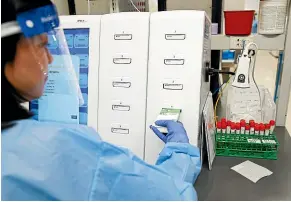  ??  ?? A laboratory technician prepares Covid-19 patient samples for testing at Northwell Health Labs in Lake Success, New York. Many US testing labs are facing severe shortages of supplies like swabs and chemicals.