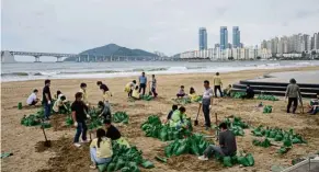  ?? — AFP ?? Taking precaution­s: District council members filling sand bags as part of preparatio­ns ahead of the arrival of Typhoon Maysak at Gwangalli beach in Busan.