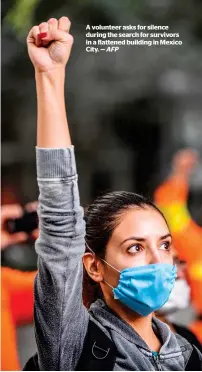  ?? — AFP ?? A volunteer asks for silence during the search for survivors in a flattened building in Mexico City.