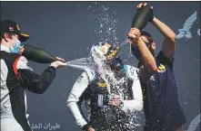  ?? PROVIDED TO CHINA DAILY ?? Zhou Guanyu is doused in champagne by rivals after the 21-year-old Chinese driver won his first F2 feature race in Bahrain on Sunday.