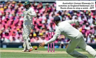  ?? ?? Australia's Usman Khawaja (L) watches as England fieldsman Joe Roots dives to stop a snick - AFP