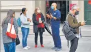  ?? AFP ?? A nurse (centre) answers queries from residents outside a vaccinatio­n centre in Melbourne.